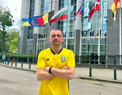 Socialdemokraternas EU-parlamentariker Adnan Dibrani i svensk fotbollströja utanför Europaparlamentet i Bryssel.
