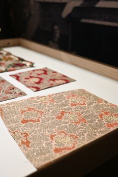 Broscherat blommotiv på beige botten med mönster i liseré Enligt uppgift från 1700-talet Teknik: Broscherat mönster på en botten i tvåskaft och liseré Material: Färgat och ofärgat silke, silverlan samt guldlan glest omlindat av ofärgat silke
