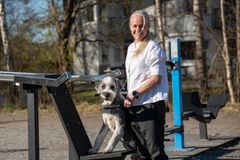 Svenska Kennelklubbens nya generalsekreterare Susanne Jidesten med sin bearded collie Ture, stående vid ett utomhusgym.