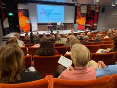 Fullsatt föreläsningssal under Blodcancerdagen med föreläsare Anton Hillblom på scenen