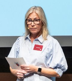 Sofia Segergren i halvbild på scenen berättar om Blodcancerföbundets arbete och insamlingar med nya 90-kontot