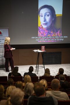 Politikern och författaren Birgitta Ohlsson på storskärm berättar om sin erfarenhet av sekundär leukemi.