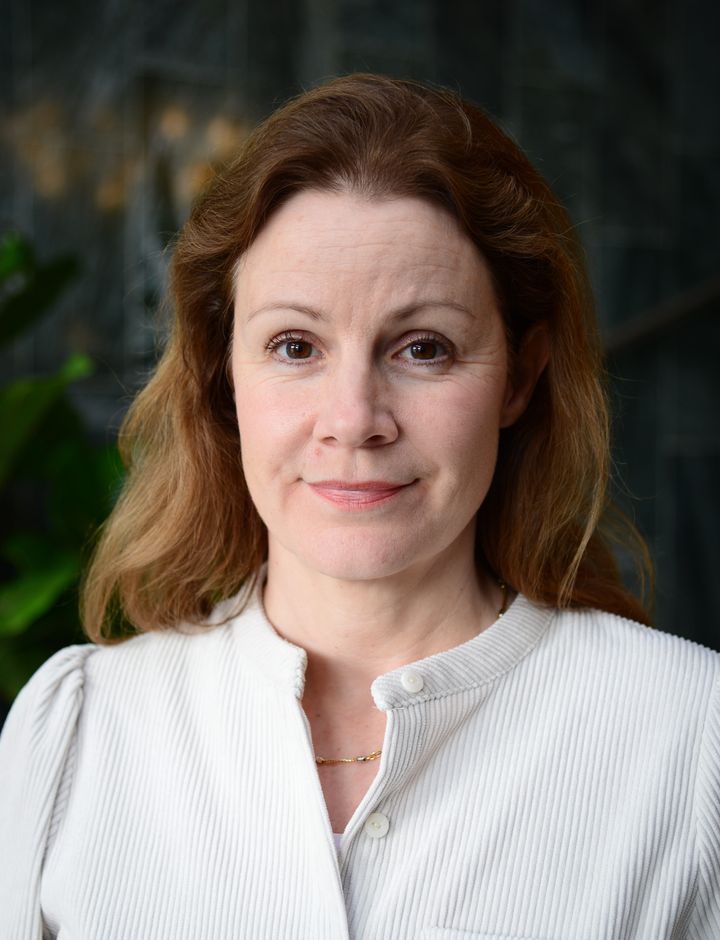 Christina Heilborn, förbundssekreterare hos Riksförbundet FUB, står framför en mörk bakgrund och tittar rakt in i kameran. Hon har en vit blus på sig.