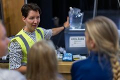 En person med gul väst står framför en grupp, pekar på en låda märkt "Krislådan".