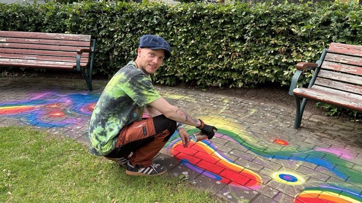 Konstnären Adam Algotsson skapar ett lekvänligt konstverk med Pride-tema