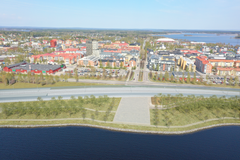 Visualisering av Norrbotniabanan genom centrala Piteå. Bilden är en tidig skiss och det är ännu inte beslutat hur passagerna över och under järnvägen ska utformas, exempelvis för Uddmansgatan. I kommande arbete med Piteå kommun kommer vi jobba vidare med passager till och från strandpromenaden vid Södra hamn, samt utformning av bullerskydd. Stationsläget planeras till vänster i bild.