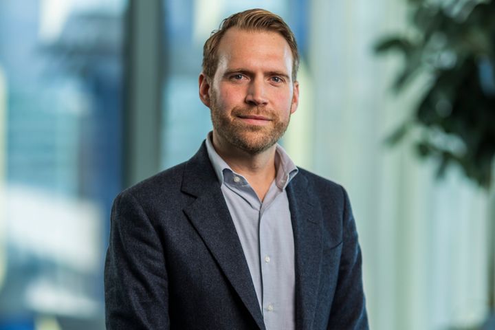 Porträtt på Albin Falkmer. Han bär en mörk kavaj och blå skjorta.