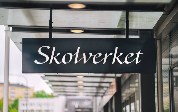 Svart skylt med vit text Skolverkets logotype