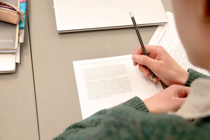 Bild över en kille som skriver ett prov i ett klassrum